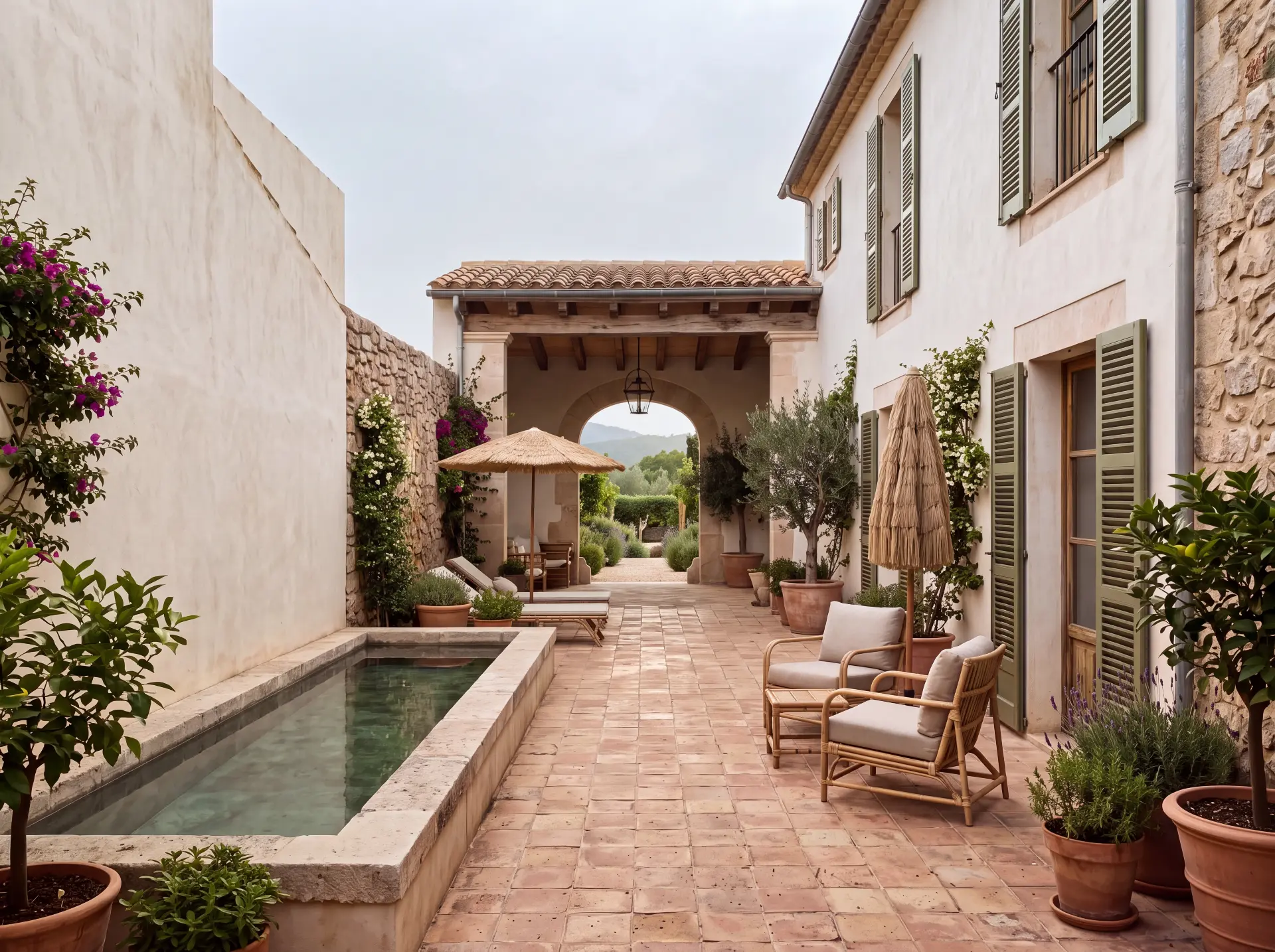 Unstyled midday photograph of the finca courtyard and narrow pool